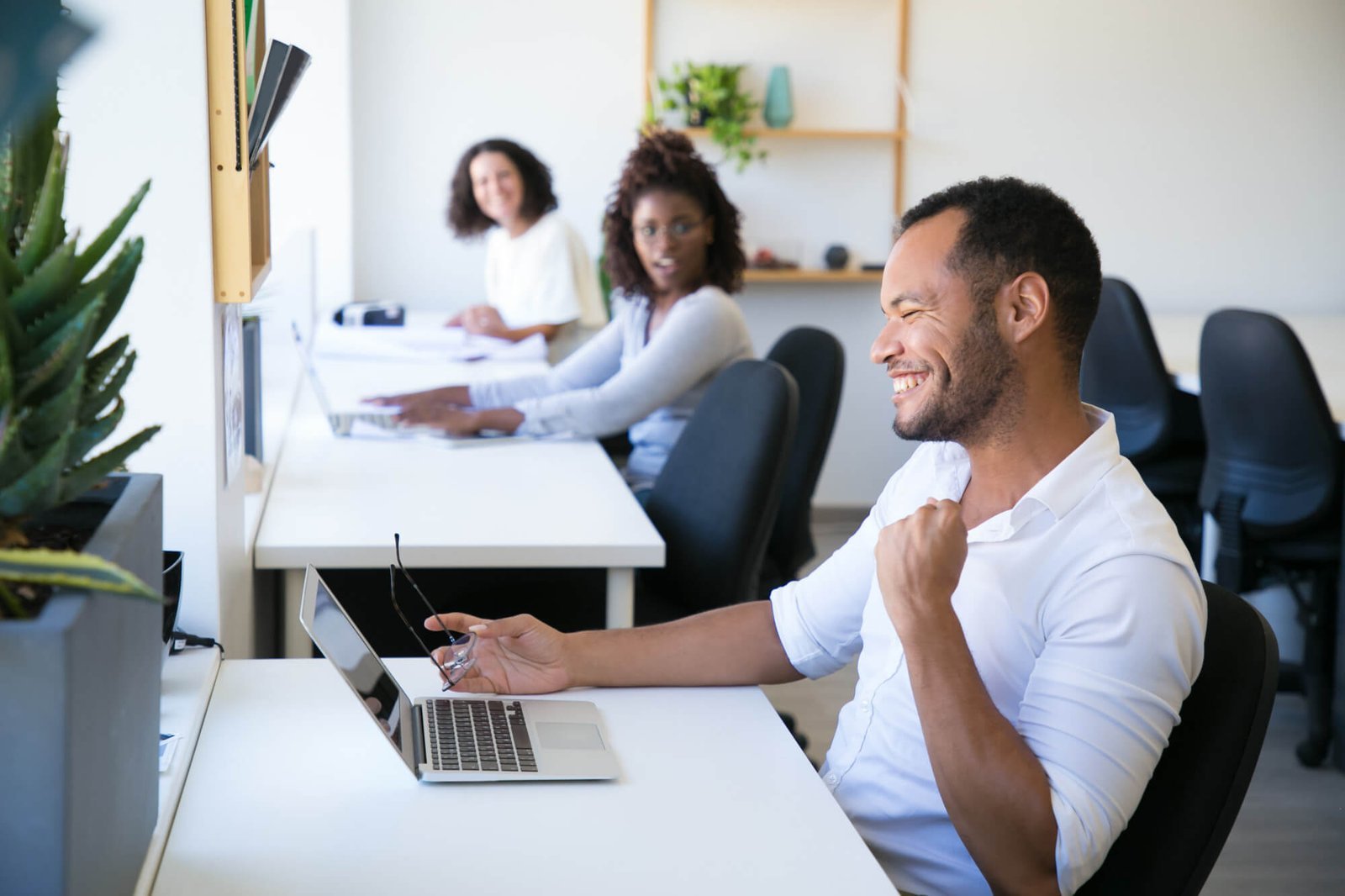 Feliz equipo de 3 personas, tomando un curso desde sus laptops | Imagen de pch.vector: Freepik